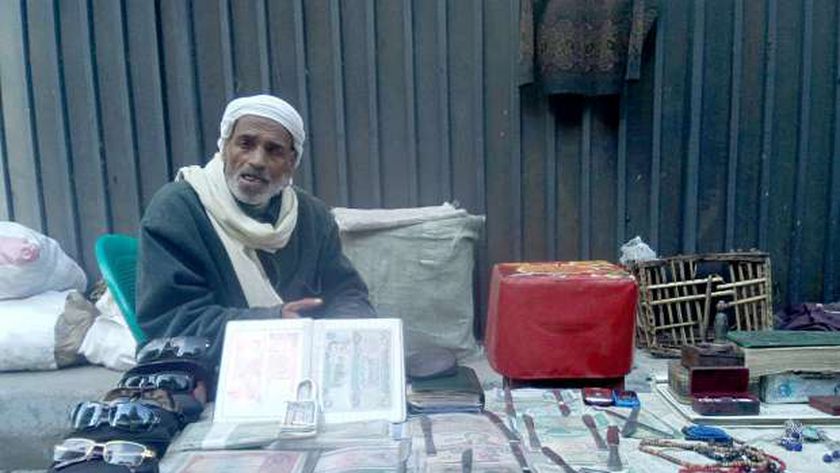 صورة “رمضان” أقدم بائع عملات بالإسكندرية يوحد بلدان العالم على الرصيف – المحافظات